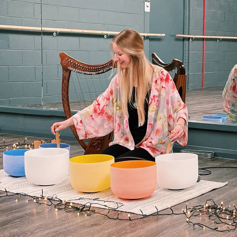 Hannah Rose performing a sound bath with tibetan bowls